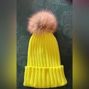 Vibrant yellow hat with pompom ball